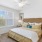 a bedroom with a large bed and a fan