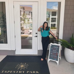 xplore our stunning community and take advantage of our amazing specials today! Don’t miss out on this opportunity to make your move into the perfect place. a woman standing at an entrance to a door with a key in front of a sign