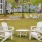a group of white chairs and tables in a park